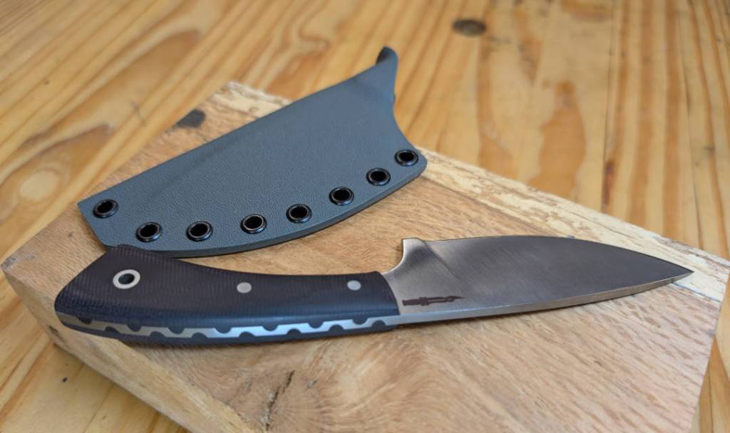 A pocket fixed blade with burgundy micarta handle and decorative filing